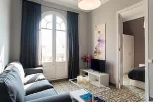 巴塞罗那巴塞罗那旅客酒店的客厅设有蓝色的沙发和窗户。