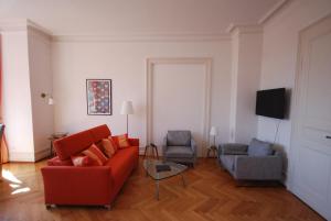 蒂宾根Appartements in zentraler Lage的客厅配有红色的沙发和两把椅子