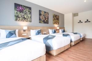 尖竹汶蓝兔酒店的酒店客房设有两张床,墙上挂有绘画作品