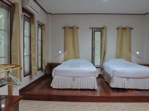 班康卡臣班马卡自然旅馆的配有窗户的客房内的两张床