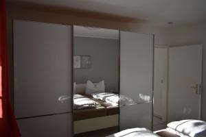 奥特里德维茨Reethaus Boddenblick的一间卧室设有两张床和大镜子