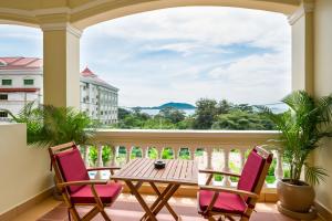 白马市Riviera Hotel & Resort Kep的阳台配有桌椅,享有海景。