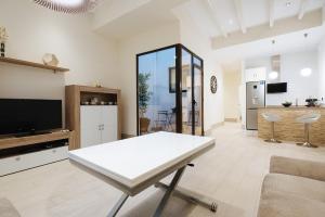 塞维利亚Luxury Apartment Peñuelas Free Parking的一间带白色桌子的客厅和一间厨房