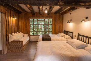 富塔莱乌富Hotel El Barranco的一间卧室设有三张床和窗户。