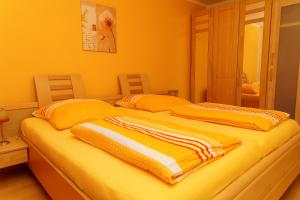 拜尔斯布龙Ferienwohnung Kaufmann的橙色墙壁和黄色的客房内的两张床