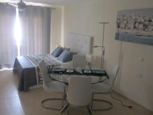 阿罗纳Los Cristianos studio, modern, spacious, pool,WiFi的卧室配有一张床和一张桌子及椅子
