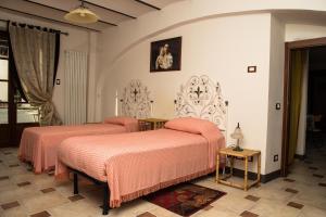 阿尔巴La Madonnina Agriturismo Dorè的一间卧室配有两张带粉红色床单的床