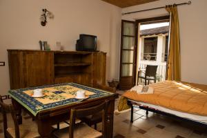 阿尔巴La Madonnina Agriturismo Dorè的一间设有桌子、床和电视的客房