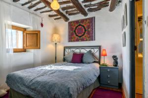 卡皮雷拉Casa Amaranta的卧室配有一张床,墙上挂有绘画作品