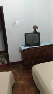 瓦拉达里斯州长市Hotel Indaiá的卧室里梳妆台上配有电视