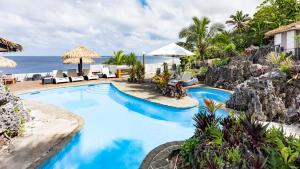 阿洛菲玛塔凡纽埃美景度假村的一个带椅子的游泳池,背景是大海