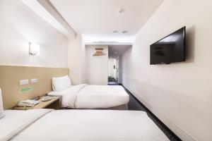 台北洛碁大饭店林森馆的酒店客房设有两张床和一台平面电视。