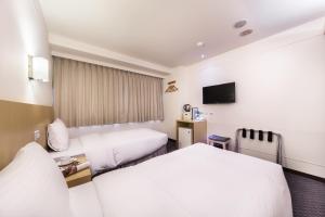 台北洛碁大饭店林森馆的一间酒店客房,设有两张床和电视