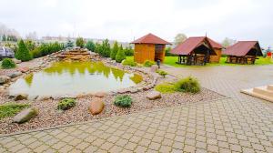 Garliava亚美尼亚酒店的庭院里的池塘,有凉亭和房子