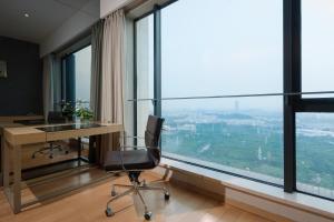 广州易成国际公寓广州琶洲保利世贸店的窗户前带桌椅的办公室