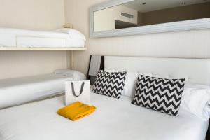 马德里珀蒂宫翠柏酒店的卧室配有白色床和墙上的镜子