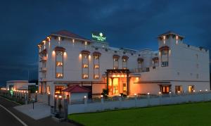 哥印拜陀哥印拜陀柠檬树酒店的一座白色的大建筑,晚上有灯