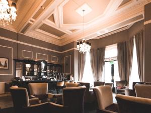 布雷得佛维多利亚豪华酒店的餐厅内的酒吧,配有椅子和吊灯