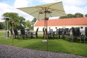 霍布罗布拉姆斯勒维嘎德酒店的草上一张桌子和椅子以及一把雨伞
