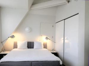 马斯特里赫特城市公寓马斯特里赫特酒店的卧室配有带两盏灯的白色床