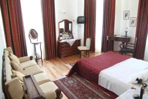 特里卡拉潘尼尔里尼恩酒店的一间卧室配有一张床、一把椅子和镜子