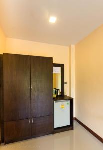 高兰Toongyoong Longbeach Resort SHA Plus的厨房配有木制橱柜和冰箱。