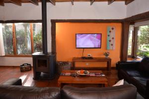 阿祖尔海森林露营地山林小屋的客厅设有壁炉和电视。