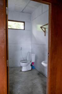 YwamaInnthar Lodge Home Stay的白色的浴室设有卫生间和水槽。