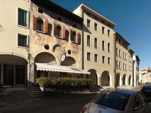 科内利亚诺Hotel Canon d'Oro的前面有停车位的建筑