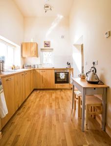 巴拉Ty'r Afon - River Cottage的厨房配有木制橱柜和桌子及水壶。