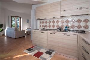 马萨鲁布朗斯Villa d'aMare Capri View的一间带木制橱柜的厨房和一间客厅