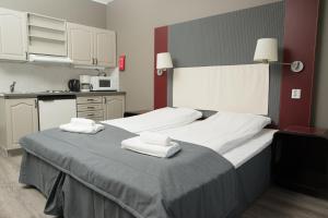 奥普达尔Oppdal Gjestetun Hotell的一间卧室配有一张大床和毛巾