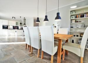 ZirchowFerienhaus Zirchow 3的厨房以及带木桌和白色椅子的用餐室。
