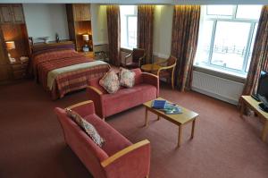 布里德灵顿艾斯派斯酒店的酒店客房配有床、沙发和桌子。