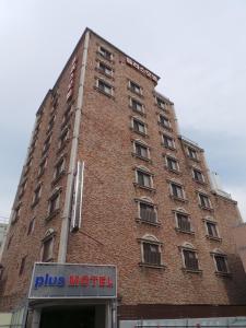 釜山普拉斯汽车旅馆的前面有标志的高高的砖砌建筑