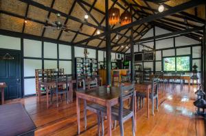 琅勃拉邦山林自然生活方式酒店的用餐室配有木桌和椅子