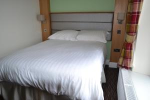 斯坦利橡树汽车旅馆的一张带白色床单和枕头的床