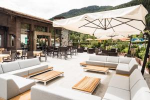 丽丹纳施内贝格家庭Spa及度假酒店的一个带沙发和桌子及遮阳伞的庭院