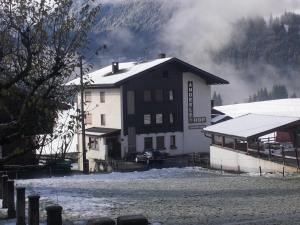 Sankt Lorenzen im LesachtalPension Anderlehof的房屋旁边的一座积雪的建筑