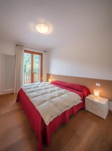 科马诺泰梅Residenza Finestra sul Parco的一间卧室设有一张大床和一个窗户。