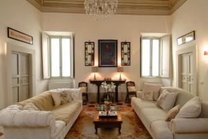 斯波莱托Palazzo Sant'Angelo的客厅配有两张沙发和一个吊灯。