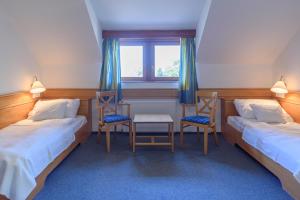 切尔塞格托毛伊多布谷马耶尔俱乐部高级酒店的客房设有两张床、两把椅子和窗户。