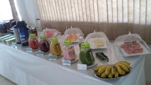 Currais Novos鲍萨达曼克斯酒店的桌子上放有瓶装果汁和水果