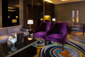 利雅德Park House的客厅配有紫色椅子和沙发
