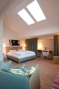 萨尔察赫河畔戈灵多勒莱尔吉尼酒店的一间大卧室,配有一张床和一把椅子