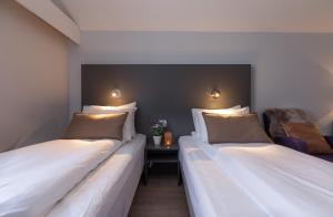 特罗姆瑟恩特维京酒店的两张睡床彼此相邻,位于一个房间里