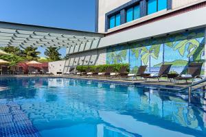 圣保罗诺富特中心北酒店的一座带椅子的建筑前的游泳池