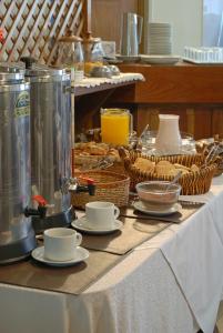 圣拉斐尔Hotel San Rafael的桌子,上面有杯子,碟子和食物篮子