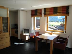朗根费尔德Ferienwohnungen Vier Jahreszeiten的客厅配有桌椅和电视。