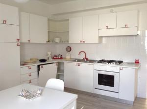 卡尔多纳佐Appartamento Balù的厨房配有白色橱柜、水槽和炉灶。